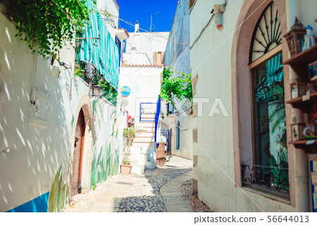The narrow streets of the island with blue balconies, stairs and flowers. 56644013