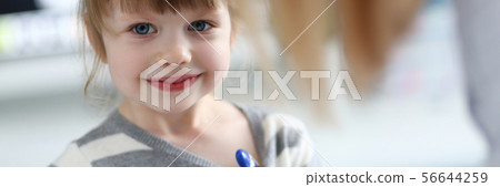 Portrait of cute little girl sitting at doctor office with thermometer 56644259