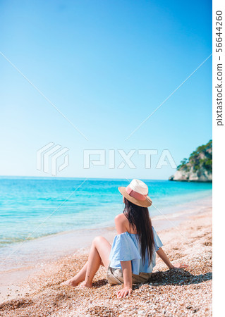 Woman laying on the beach enjoying summer holidays looking at the sea 56644260