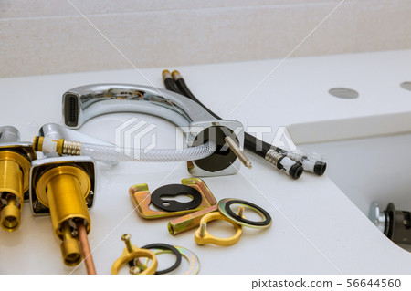 New faucet lies on the ceramic sink in the New faucet lies on the ceramic sink in the 56644560