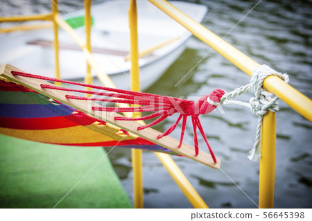 The backyard rope hammock held by metal railing 56645398