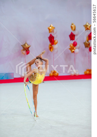 Beautiful little active gymnast girl with her performance on the carpet 56645617
