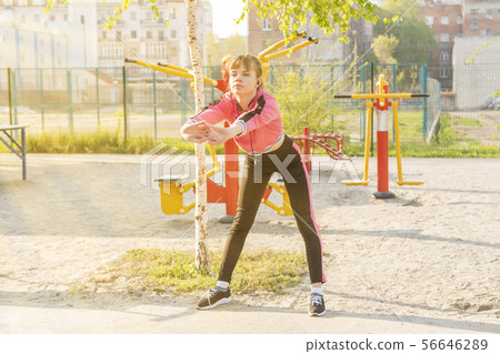 woman bends forward on the playground 56646289