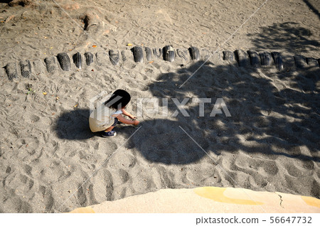 A girl playing in a sandbox A girl playing in a sandbox 56647732