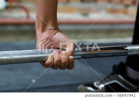 Hand athlete holding the bar neck. The athlete holds the bar. Hand athlete holding the bar neck. The athlete holds the bar. 56647941
