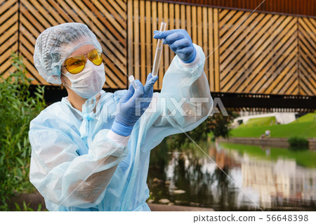 female ecologist or epidemiologist checks water 56648398