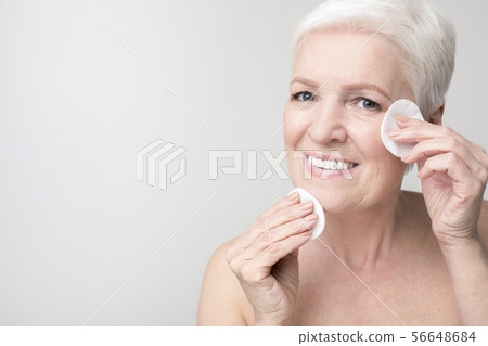 Mature woman using cotton pad for removing make up 56648684