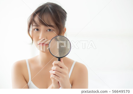 Beautiful young asian woman with magnifying Beautiful young asian woman with magnifying 56649570
