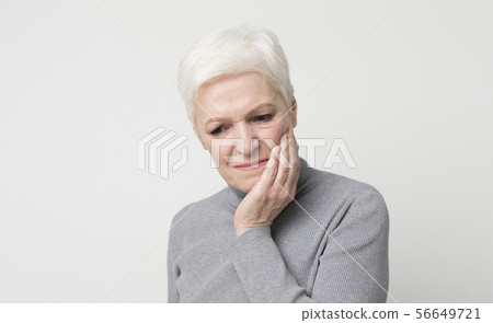 Elderly woman suffering from sudden tooth pain, panorama 56649721