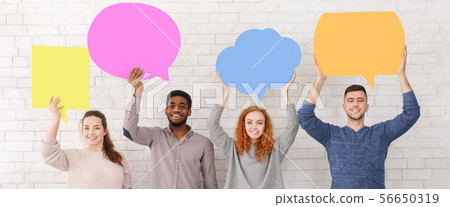 Friends holding speech bubbles and looking at camera 56650319