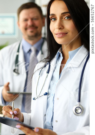 Group of smiling GP standing in office in line 56652767