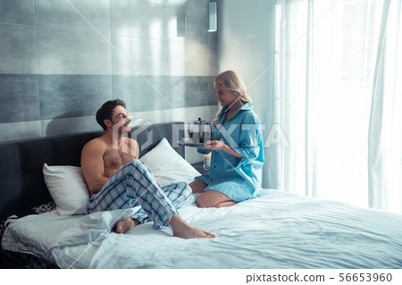 Loving girlfriend bringing coffee to bedroom for her man Loving girlfriend bringing coffee to bedroom for her man 56653960