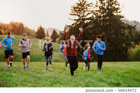 Large group of people cross country running in nature. 56654472