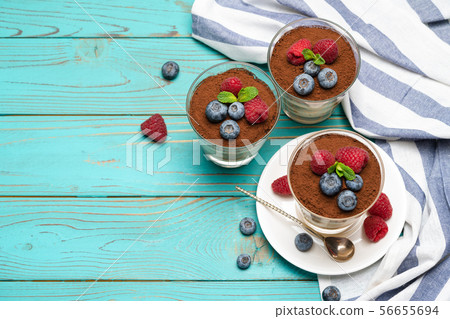 Classic tiramisu dessert with blueberries and strawberries in a glass cup on wooden background 56655694