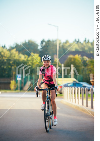 Picture of young woman in helmet on bike ride on summer day 56656189