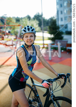 Photo of young woman in helmet on bike ride on summer day Photo of young woman in helmet on bike ride on summer day 56656221