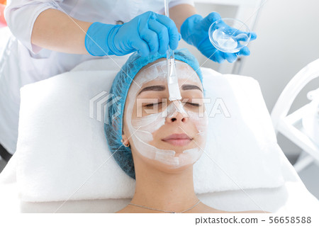 A professional cosmetologist applies a nourishing A professional cosmetologist applies a nourishing 56658588