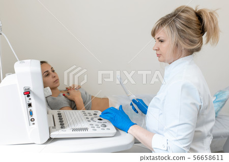 The gynecologist sets up the ultrasound machine 56658611