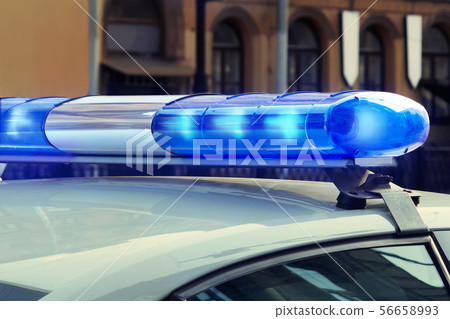 Blue signal lights on the roof of a police patrol car 56658993