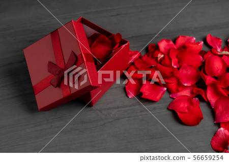 Beautiful red roses next to a gift red box on a 56659254