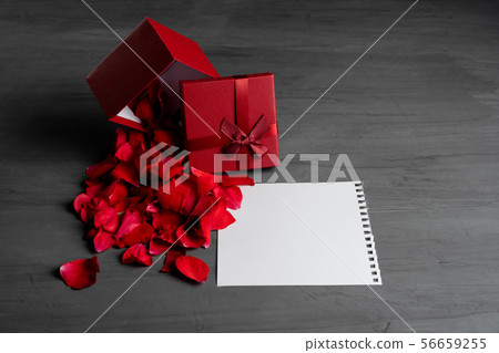 Beautiful red roses next to a gift red box on a 56659255