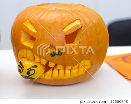 Halloween big orange pumpkin decorated with scary face. Jack O' Lantern on white table background 56660248