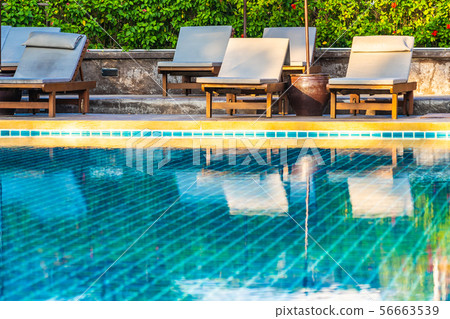 Umbrella and chair around swimming pool in hotel resort neary sea ocean beach for vacation Umbrella and chair around swimming pool in hotel resort neary sea ocean beach for vacation 56663539