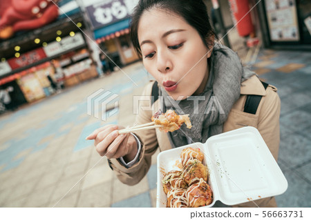 woman tourist tasting japanese local tasty food woman tourist tasting japanese local tasty food 56663731