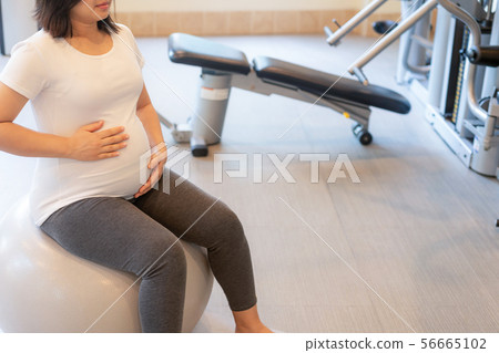 Active pregnant woman exercise in fitness center. 56665102