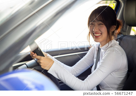 Asian women driving a car and smile happily Asian women driving a car and smile happily 56671247