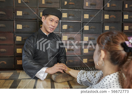 Medicine practitioner touching pulse of patient Medicine practitioner touching pulse of patient 56672773