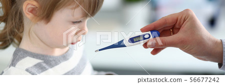 Female hand holding thermometer measuring sick little girl 56677242