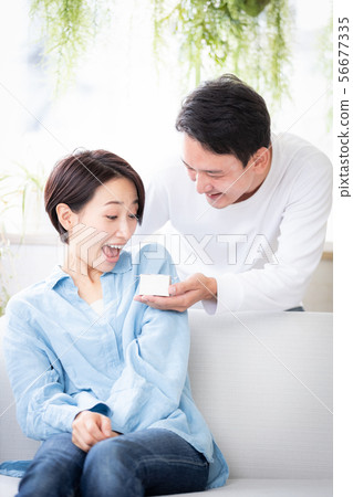 Surprise couple married couple giving present Surprise couple married couple giving present 56677335