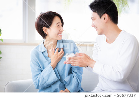 Surprise couple married couple giving present 56677337