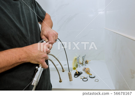 Plumber installing a faucet in a bathroom, only Plumber installing a faucet in a bathroom, only 56678167