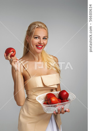 young woman holding red apple young woman holding red apple 56680634