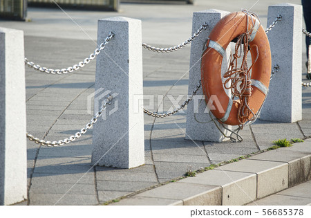 救生圈掛在岸邊的籬笆上 救生圈掛在岸邊的籬笆上 56685378