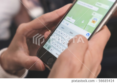 Woman typing on mobile phone Woman typing on mobile phone 56685414