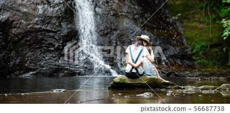 Mother and kid playing in waterfall 56687738