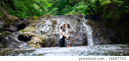 Mother and kid playing in waterfall Mother and kid playing in waterfall 56687743