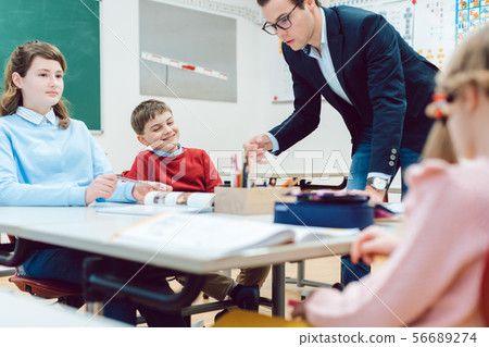 Pupils and teacher cooperating in teamwork exercise 56689274