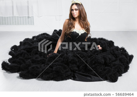 Adorable young woman poses in a studio. 56689464