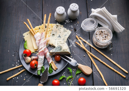 Still life of snacks, jamon, assorted cheeses 56691320