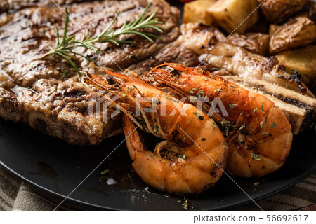 surf and turf, ribeye steak and grilled prawn 56692617