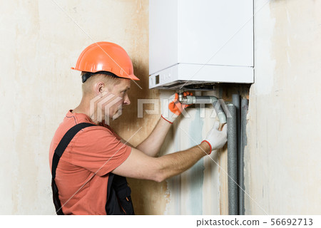 The worker is installing the gas boiler pipes 7602 The worker is installing the gas boiler pipes 7602 56692713