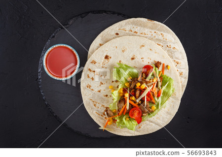 Meat and vegetables wraps. 56693843