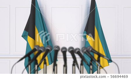 Bahamian official press conference. Flags of the Bahamas and microphones. Conceptual 3D rendering Bahamian official press conference. Flags of the Bahamas and microphones. Conceptual 3D rendering 56694469