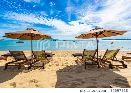 Beautiful tropical beach sea and ocean with coconut palm tree and umbrella and chair on blue sky and white cloud Beautiful tropical beach sea and ocean with coconut palm tree and umbrella and chair on blue sky and white cloud 56697218