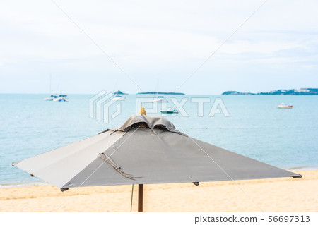 Beautiful tropical beach sea and ocean with coconut palm tree and umbrella and chair on blue sky and white cloud Beautiful tropical beach sea and ocean with coconut palm tree and umbrella and chair on blue sky and white cloud 56697313