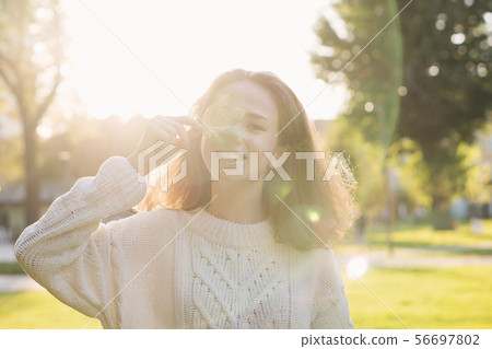 Portrait of teen girl with maple leaf Portrait of teen girl with maple leaf 56697802